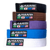 A stack of Vulkan BJJ belts in various colors including black, brown, purple, blue, and white, each with the Vulkan logo.