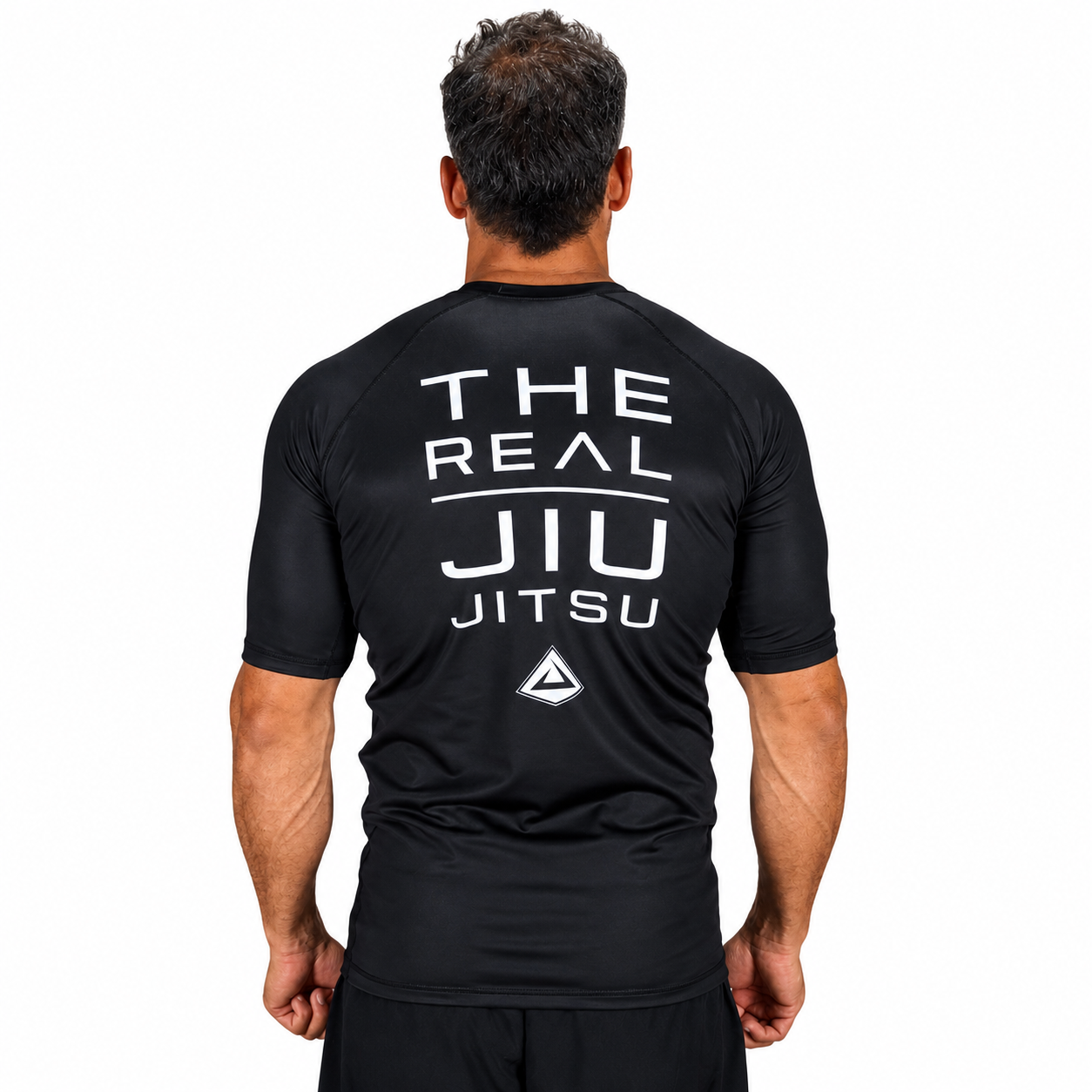 A man wearing a black short-sleeve athletic rash guard with a white VULKAN logo printed on the chest, set against a plain white background.